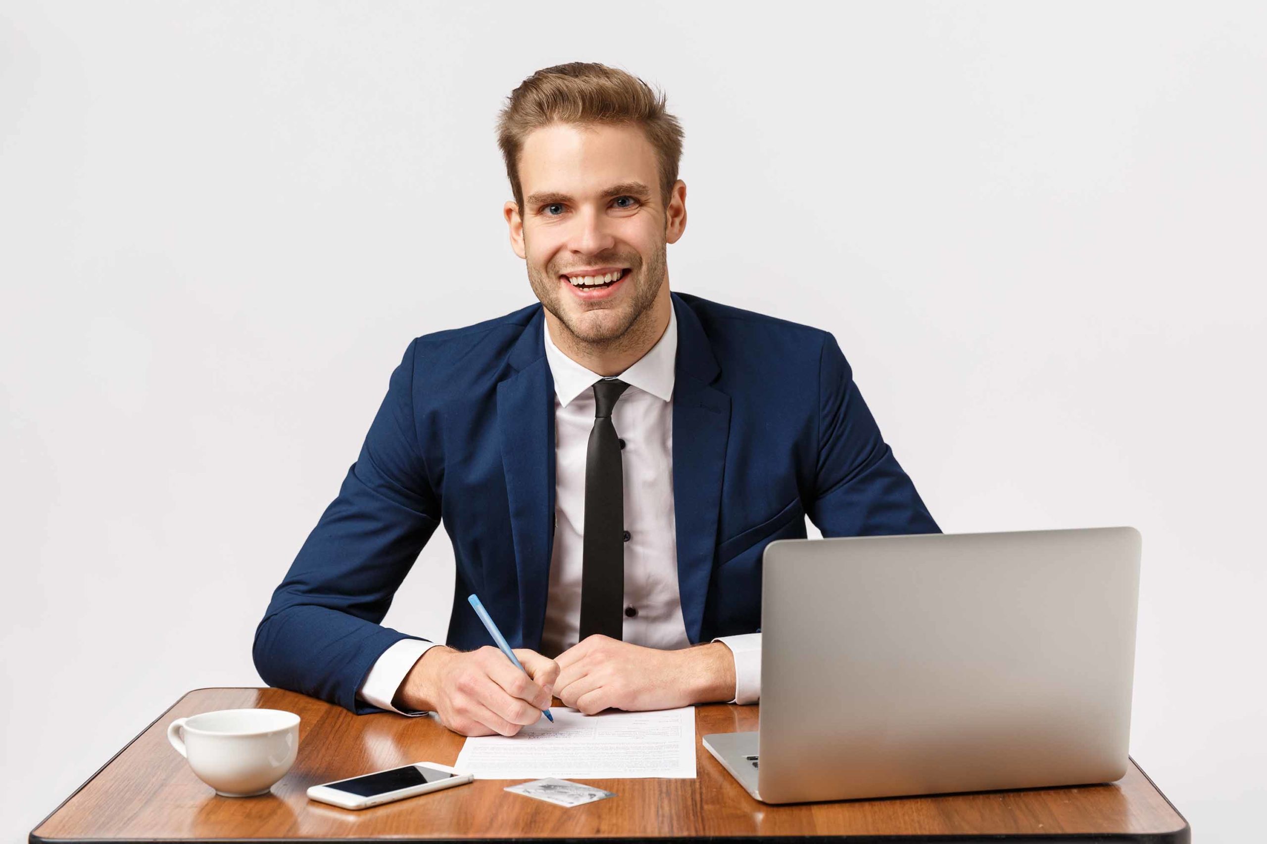 Business, office and corporate concept. Handsome, cheerful blond bearded guy in classic suit, sitting table, company desk with laptop, papers smartphone and cup coffee, write report, manage business.